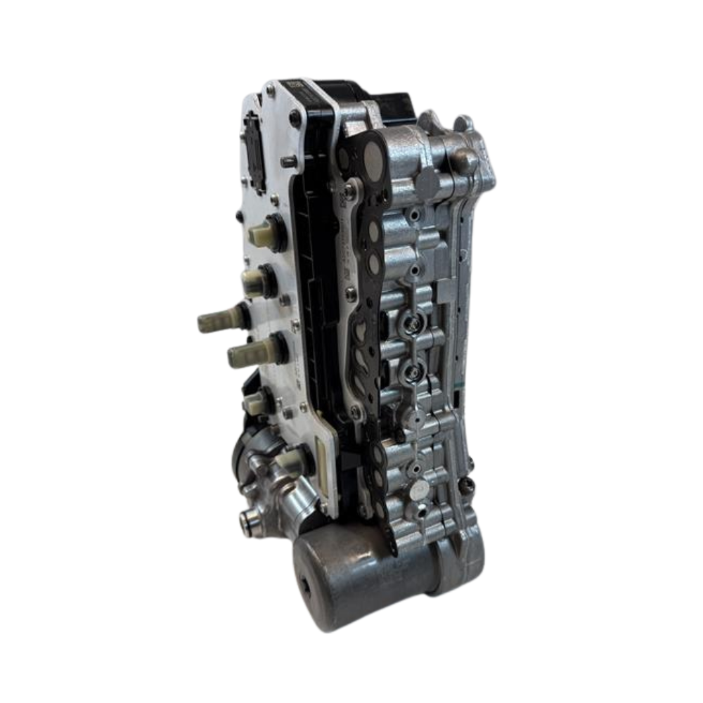 Side profile of a 0DD DQ400e mechatronic unit photographed on a workshop surface